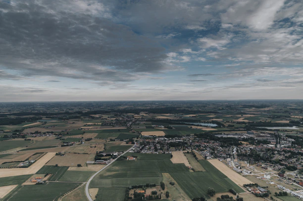 Aerial view of a rural landscape with soybean and corn fields under a clear sky.
