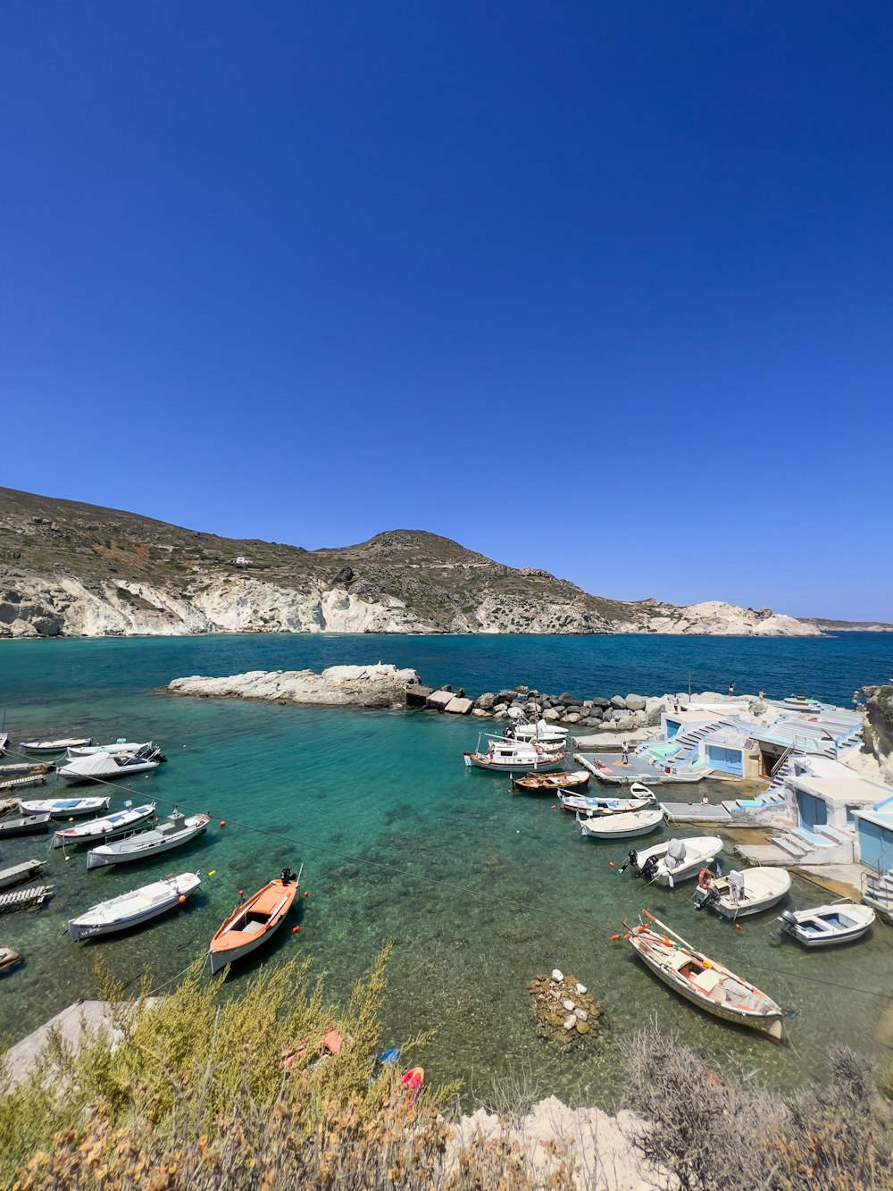 a bay with boats and a hill in the background