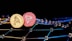 Two virtual coins, one gold with a bear symbol and another pink featuring a triangular logo, are positioned against a backdrop of interconnected digital nodes. The image conveys a futuristic and technological ambiance.