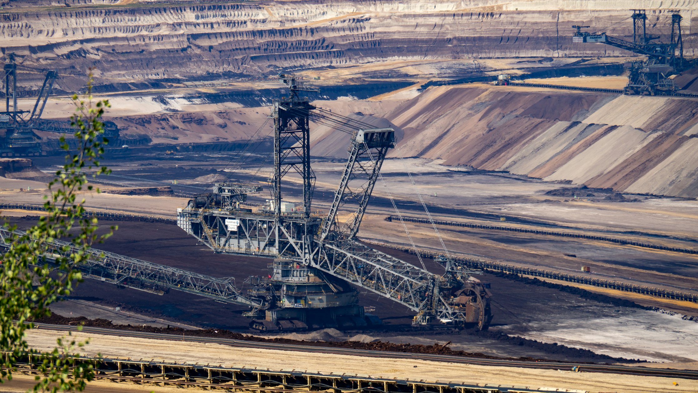 Open-pit mine landscape under dramatic sky