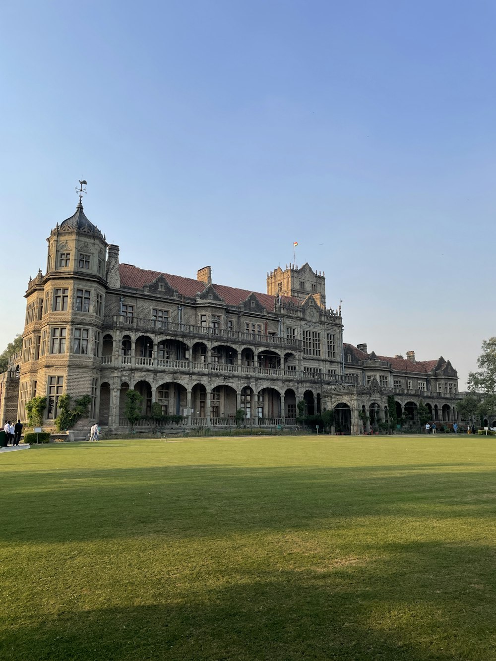 a large building with a lawn in front of it with Rashtrapati Niwas in the background