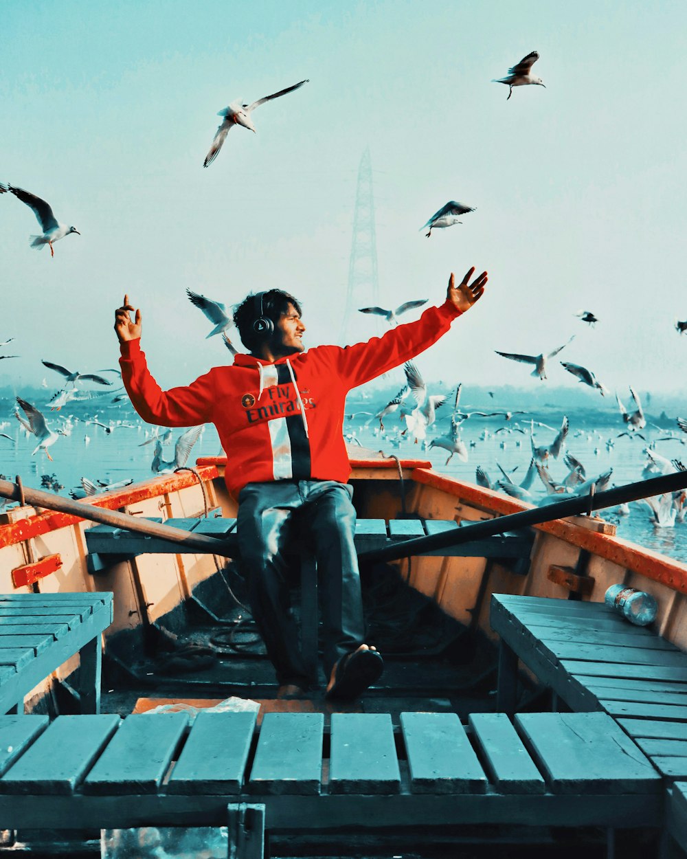 a person with a camera on a dock with birds flying in the sky