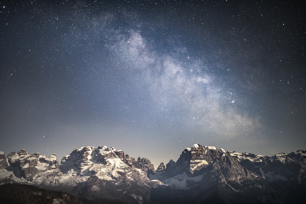a snowy mountain range with stars in the sky