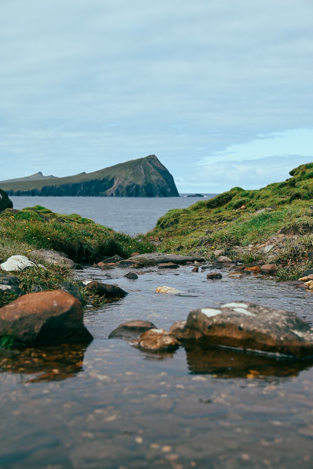 a rocky beach with a large body of water in the background