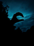 Hands holding a medallion against the backdrop of a vibrant Sedona vortex site with swirling clouds