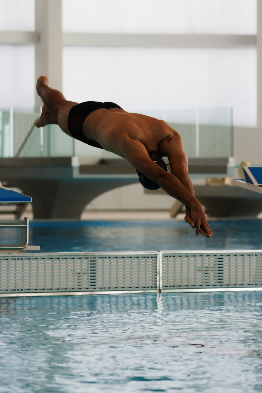 uma pessoa pulando em uma piscina