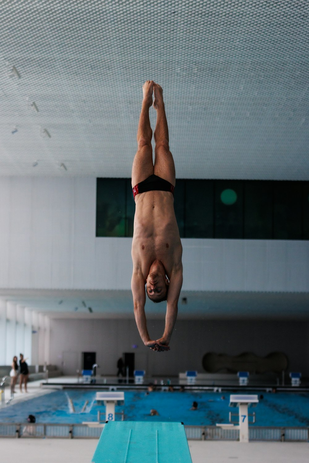 a person doing a handstand on a mat in a gym