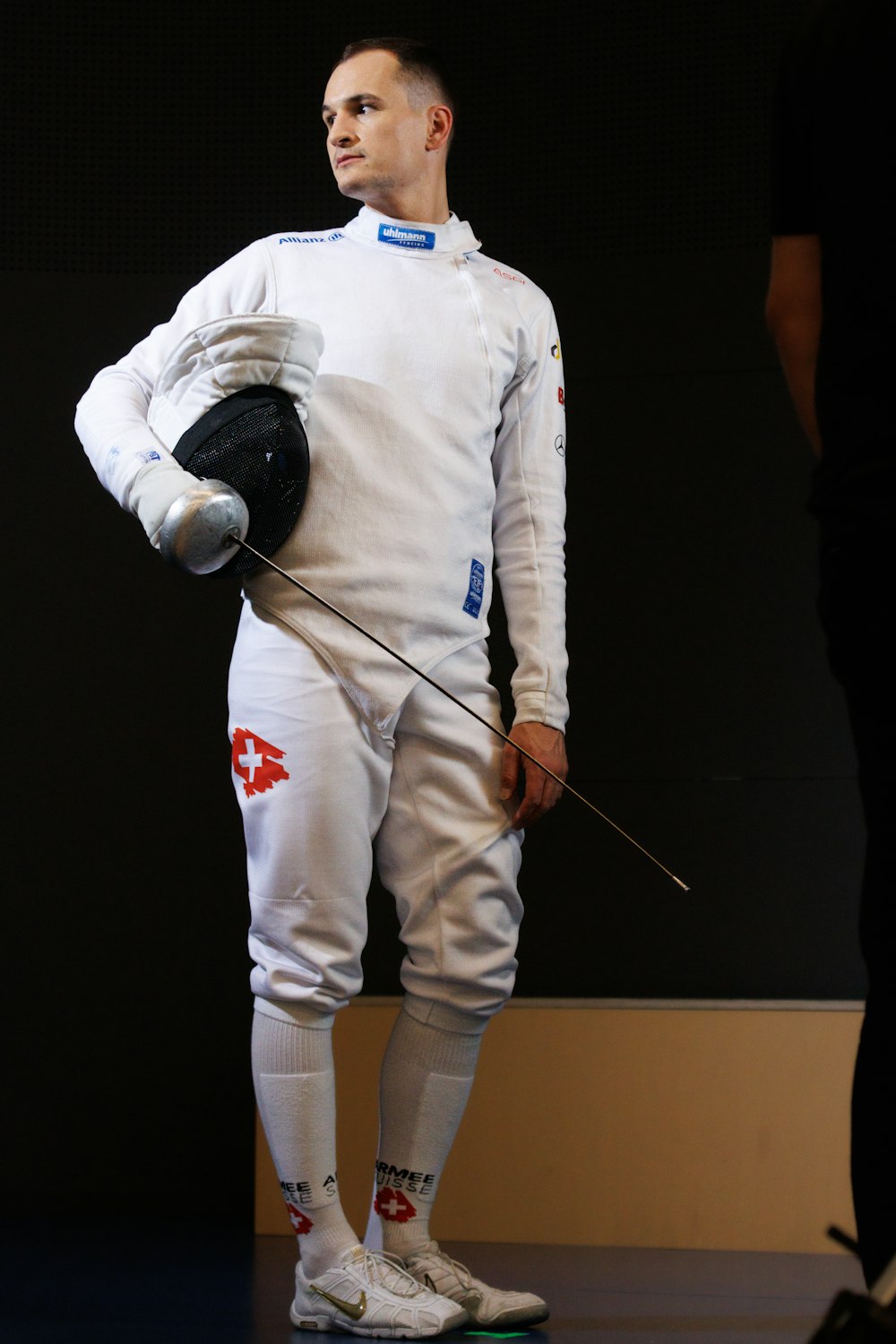 a man in a white uniform holding a hockey stick