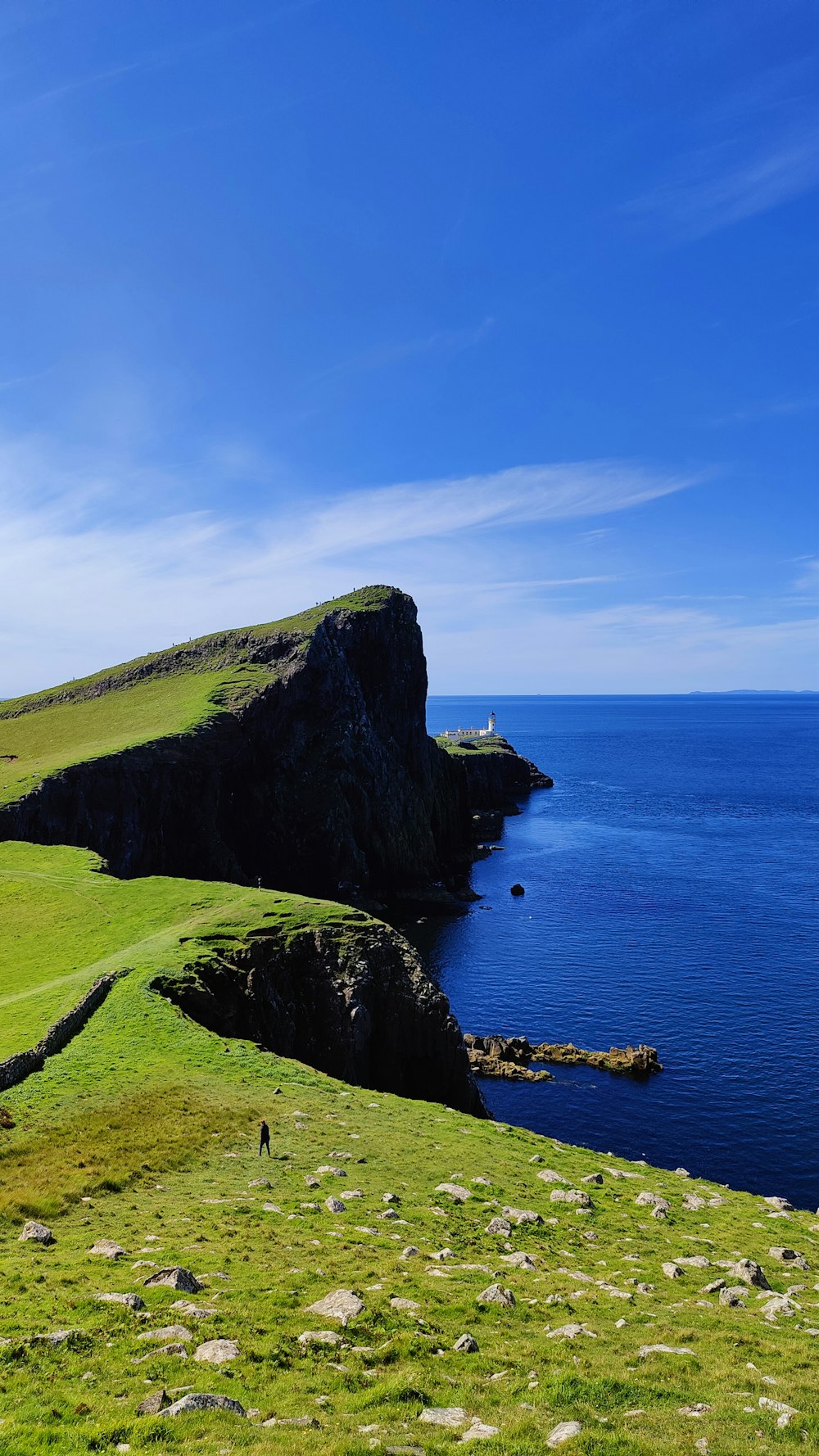 a grassy hill overlooking a body of water