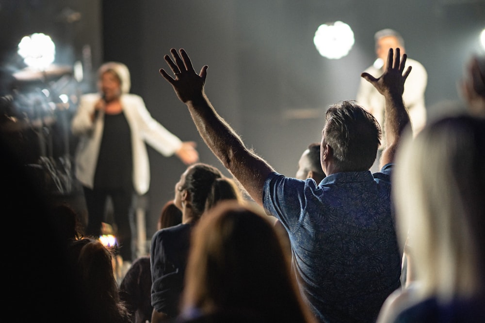 a person with the hands up in the air in front of a crowd