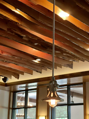 A warm, inviting office space with wooden beams and natural light highlighting craftsmanship.