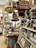 A nostalgic general store displaying a variety of vintage products and advertisements. Shelves are filled with jars of preserves and snacks, and old-fashioned signs such as Coca-Cola and Donald Duck Bread add a retro charm. The store has a cluttered but welcoming atmosphere, with barrels, bags of popcorn, and a colorful assortment of goods.