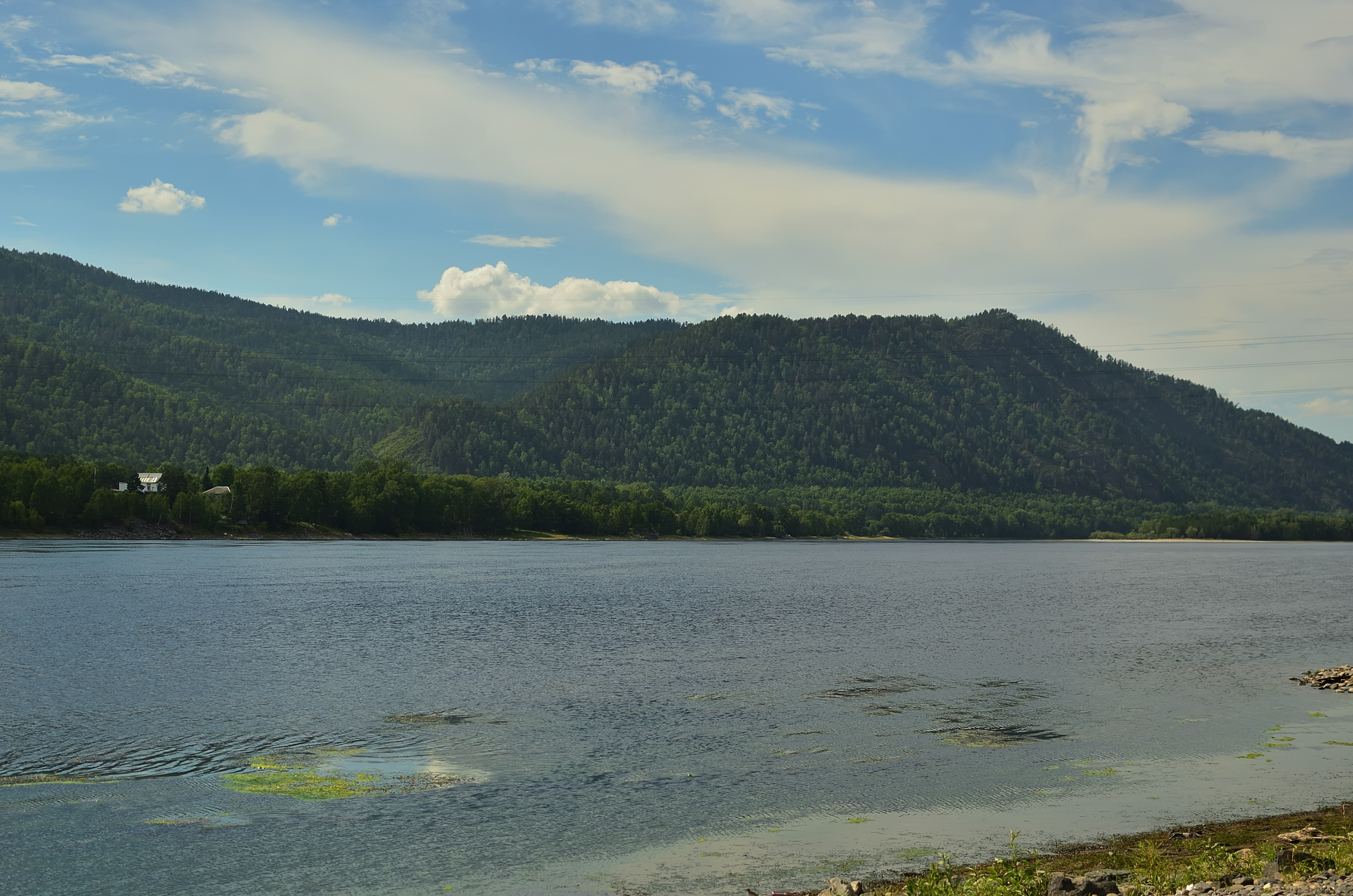 a lake with trees and mountains in the background