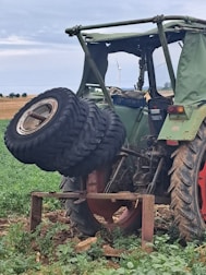 Tractor being serviced outdoors with tools and equipment.