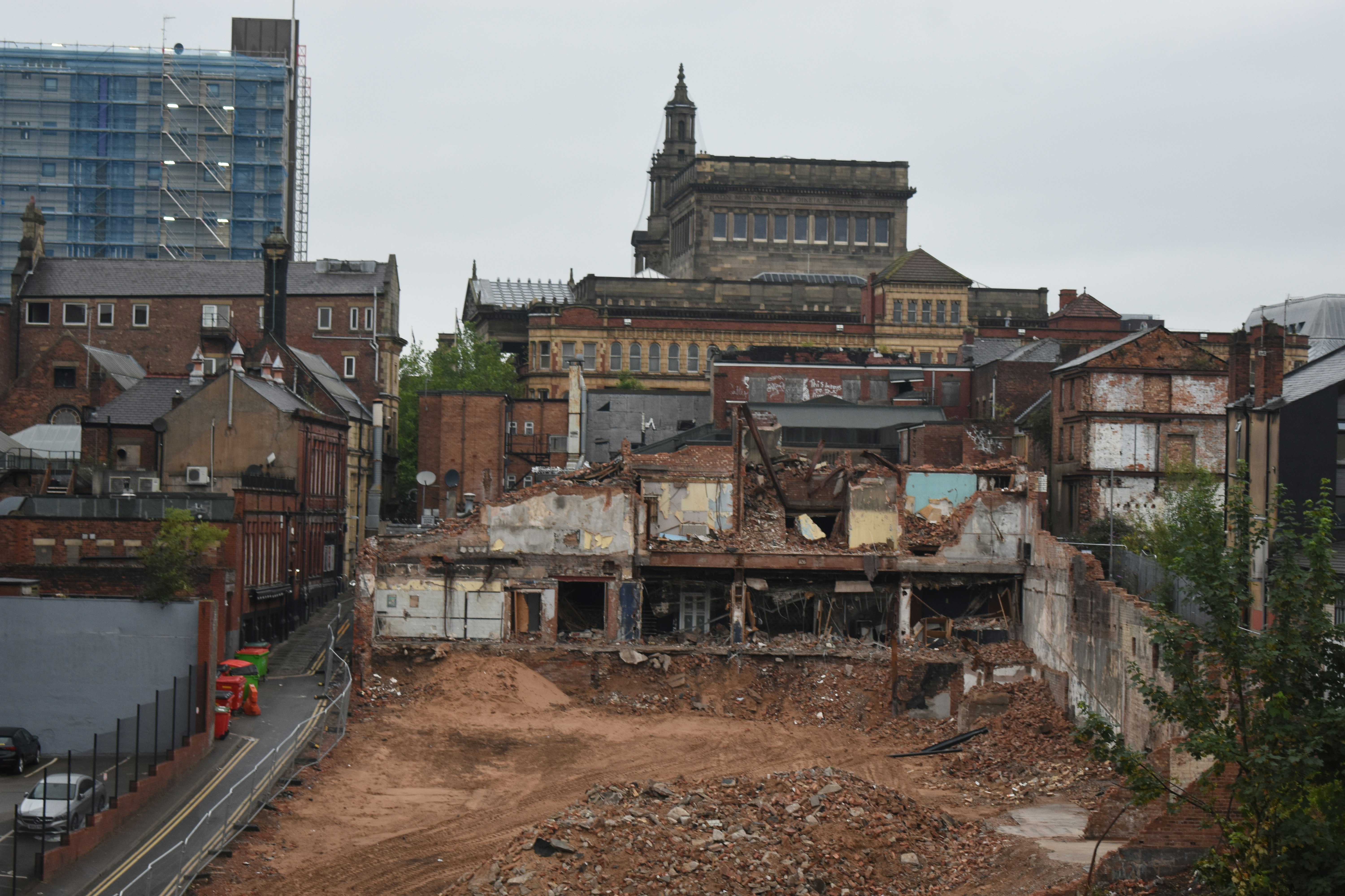 Outdoor pile of construction rubble and broken materials, overcast sky, gritty dark industrial setting