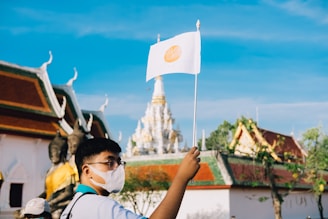 Traveler wearing a mask with a backdrop of international landmarks symbolizing Covid coverage.