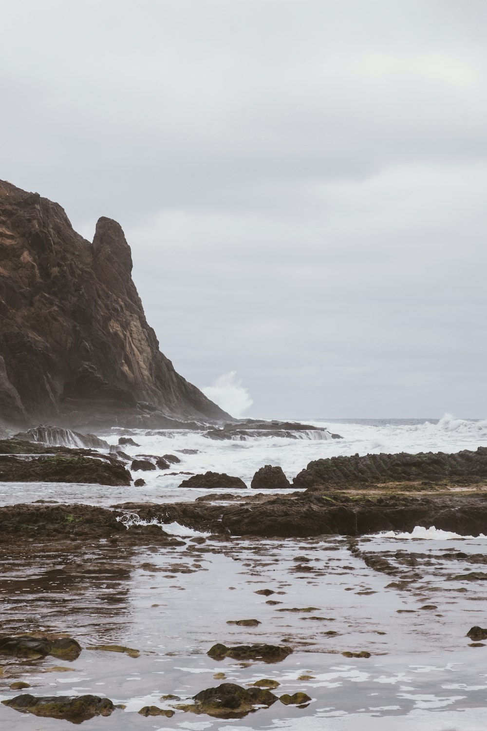 a rocky beach with a large cliff