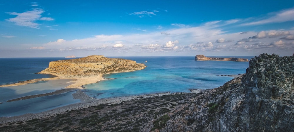 a beach with blue water and rocks