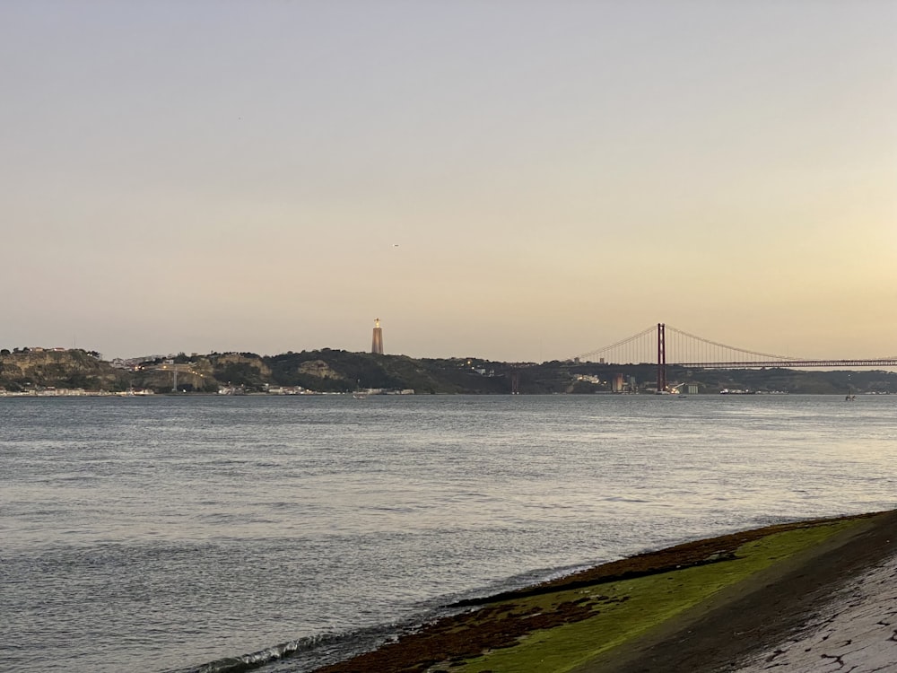 a body of water with a bridge in the distance