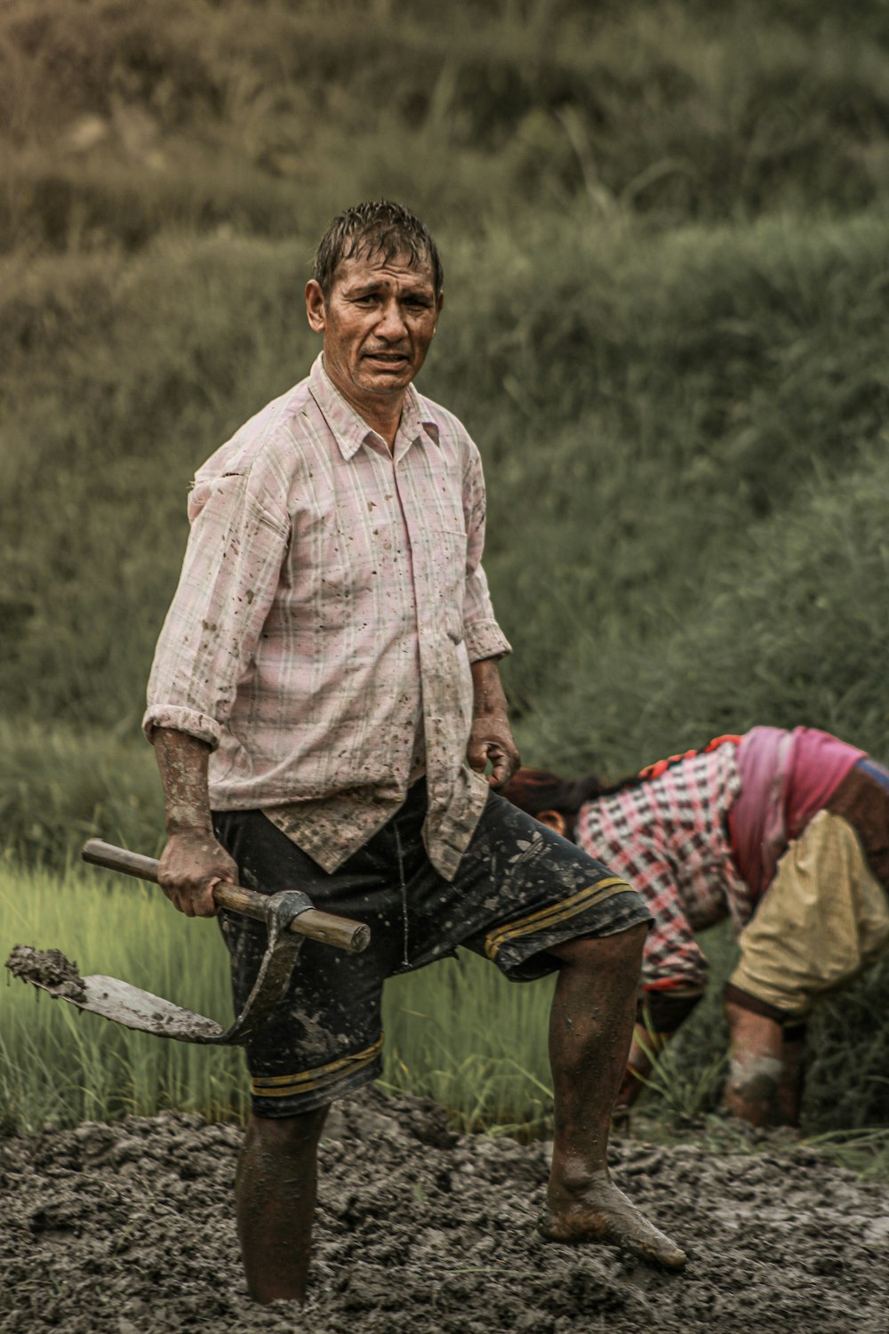 a man holding a stick and a man lying on the ground