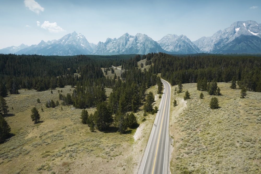 a long road going through a valley with mountains in the background