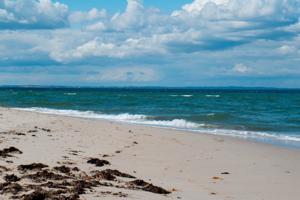 Une plage avec de l’eau bleue et des nuages