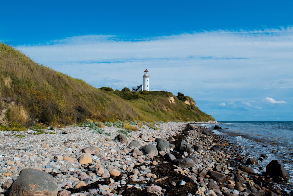 a rocky beach with a lighthouse
