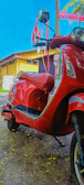 A shiny red Activa 6G scooter parked near colorful Goan street art.
