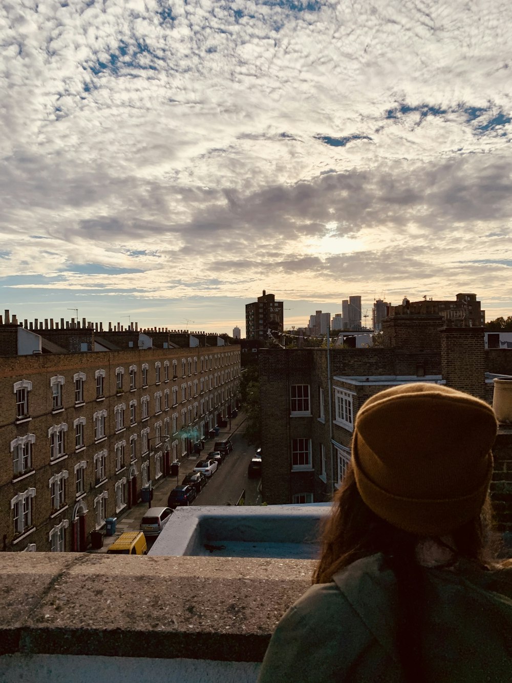 a person looking out a window at a city