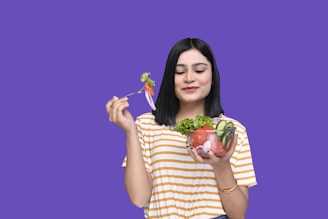 a woman holding a bowl of fruit