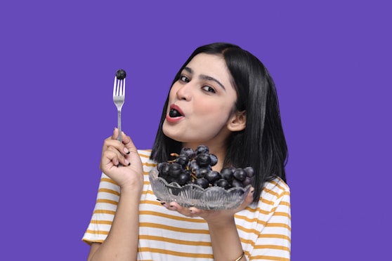 a woman holding a plate of grapes