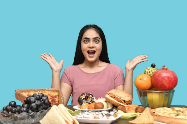 a woman with her mouth open and hands up in front of a table of food