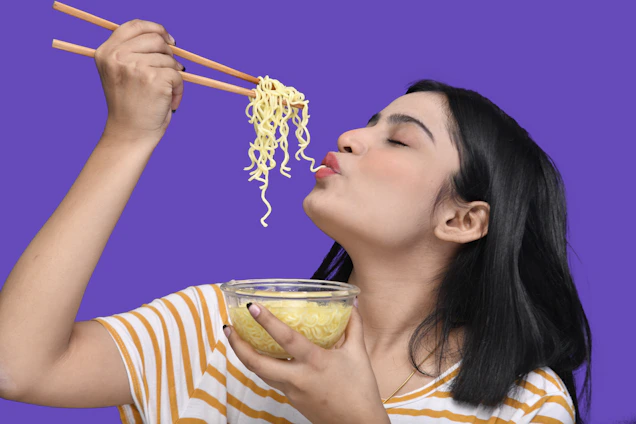 Close-up of a person savoring a colorful dish with eyes closed, enjoying the taste deeply.