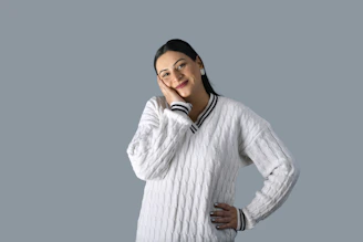 Snowboarder relaxing indoors, wrapped in a cozy white sweater with subtle black accents.