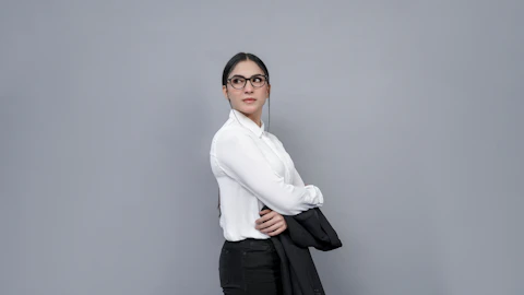 Medium shot — waist-up business portrait of an Asian woman in white shirt holding a jacket