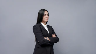 A professional black woman confidently speaking on the phone in a modern office.