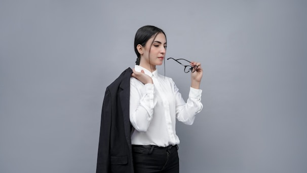 A bright, airy portrait of a woman wearing Dual Clear glasses, smiling gently against a clean white background
