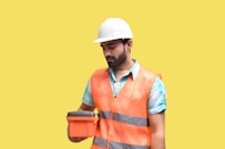 A professional wearing a hard hat and safety vest conducting a workplace safety inspection.
