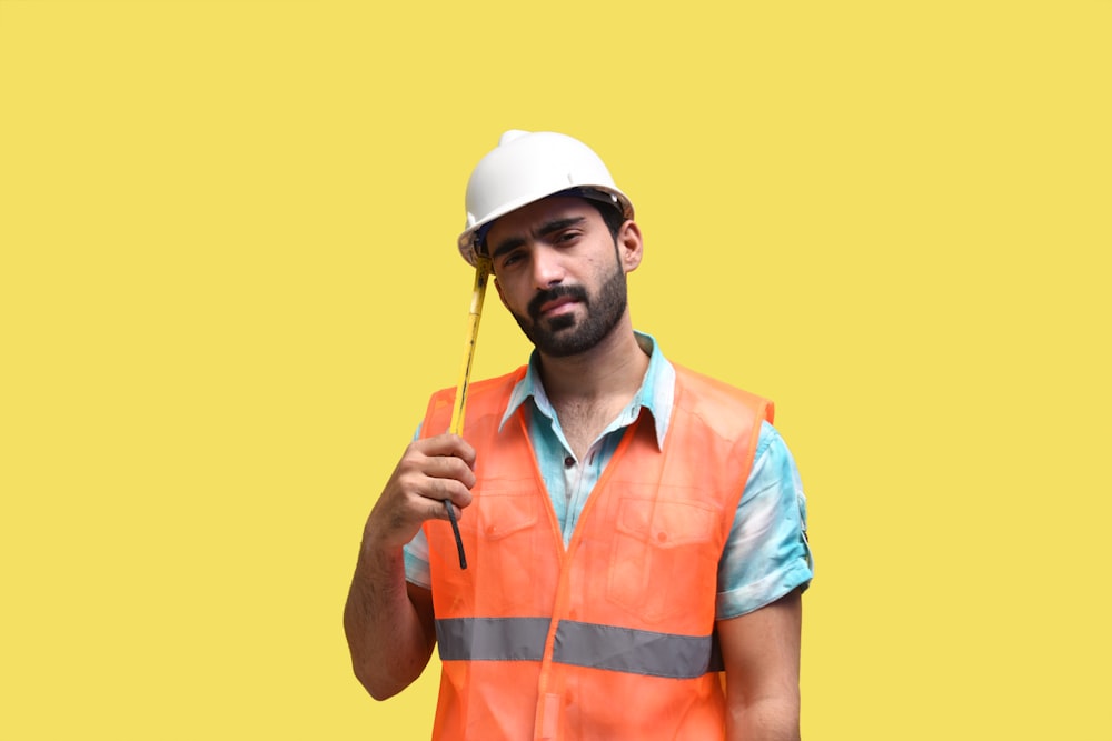 a man wearing a hard hat and holding a stick