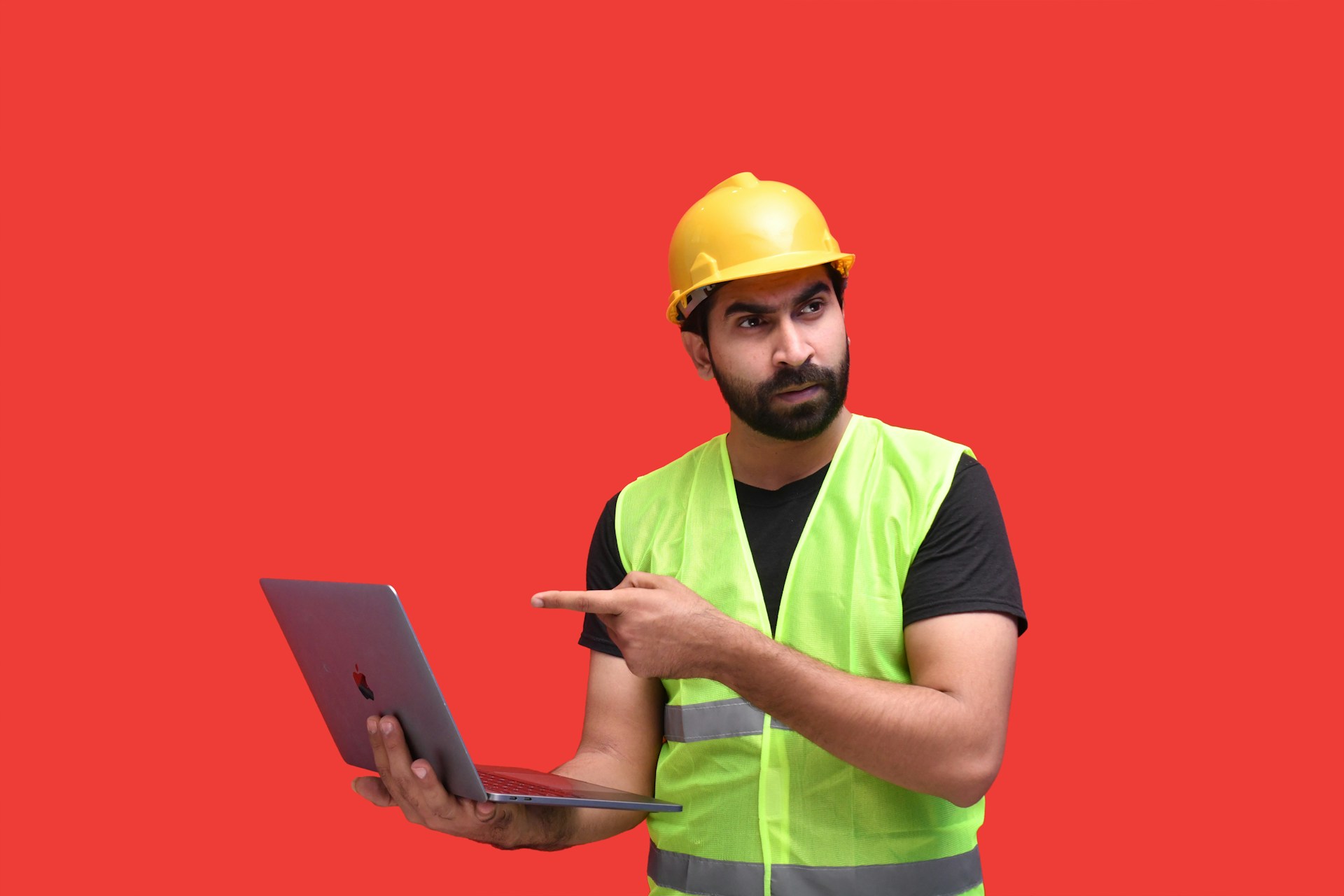 a man wearing a hard hat and holding a laptop