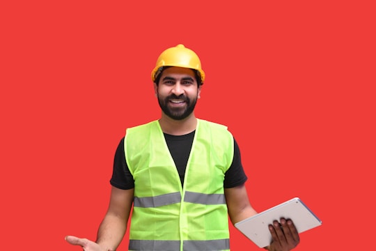 a man wearing a safety vest and holding a piece of paper