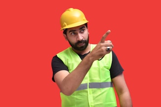 a person wearing a hard hat and holding up the middle finger