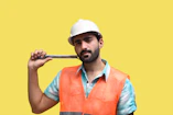 a man wearing a hard hat and holding a gun