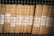 Stacks of organized brown files are secured behind a wire mesh. Each file is labeled with handwritten tags displaying the numbers 1956 and codes like 343 and 352. The scene reflects a methodical storage system, possibly for records or documents.