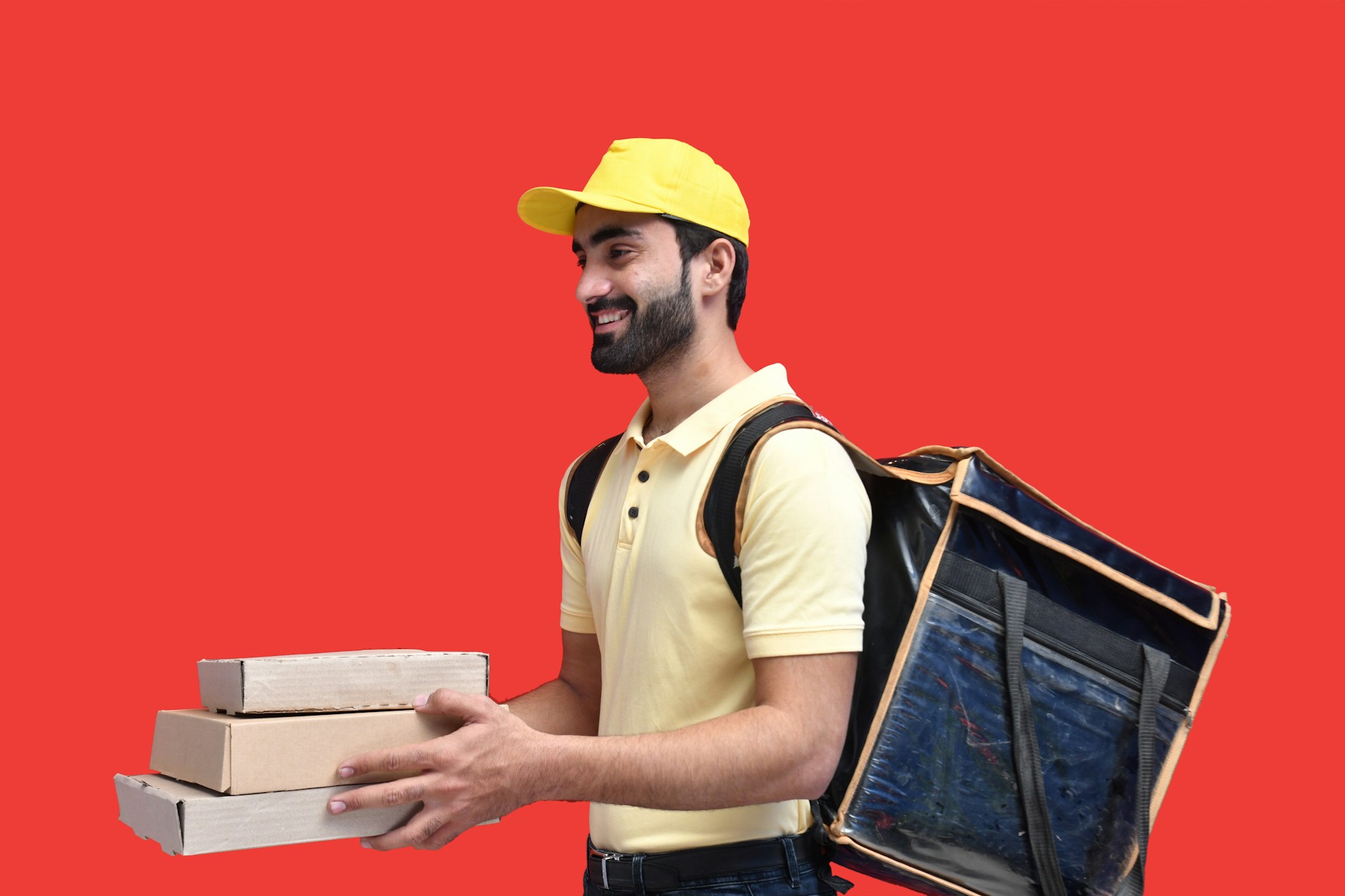 a man in a yellow hat holding a box and a laptop