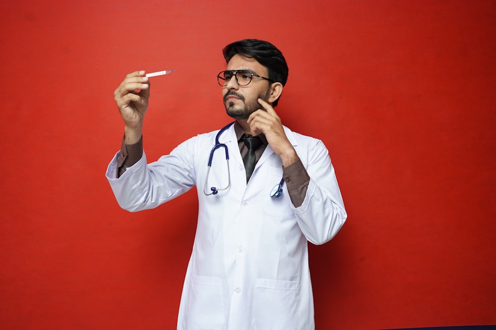 a man in a white coat holding a cigarette