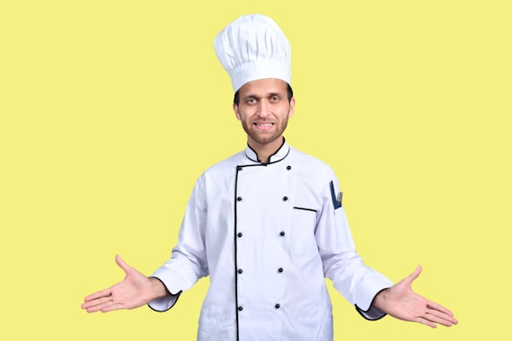 a man wearing a chef's hat and standing in front of a yellow background