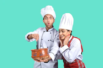 a man and a woman wearing white hats and holding a bucket