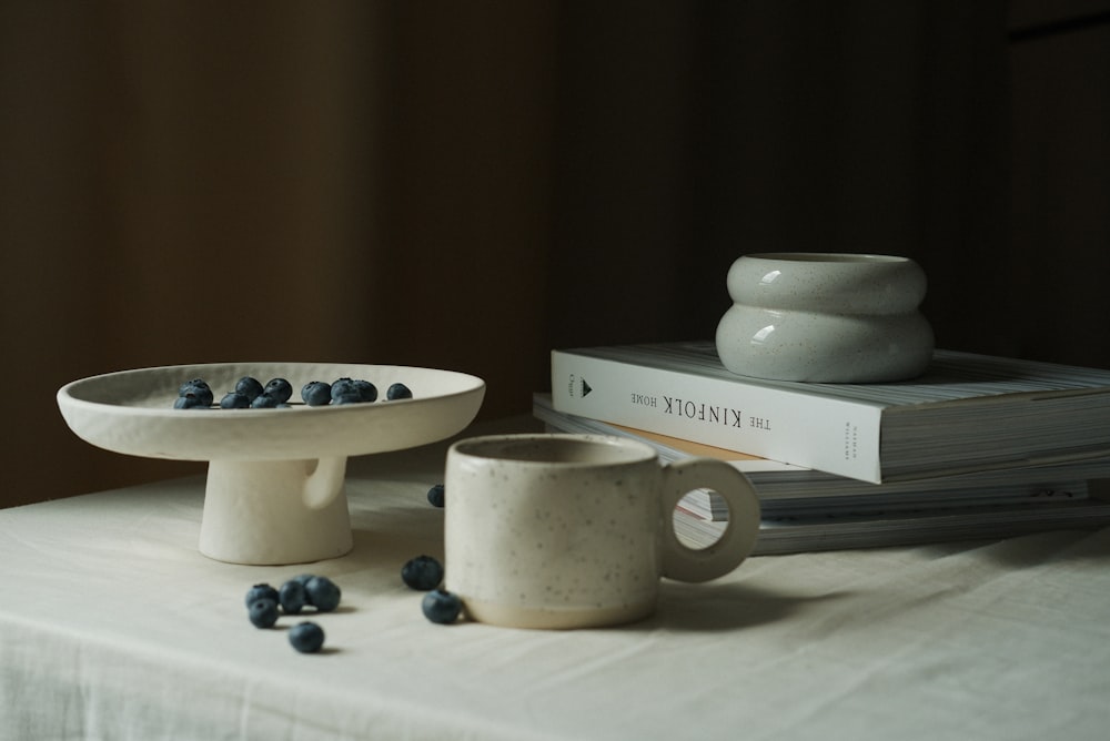 a bowl of blueberries and a bowl of cereal on a table