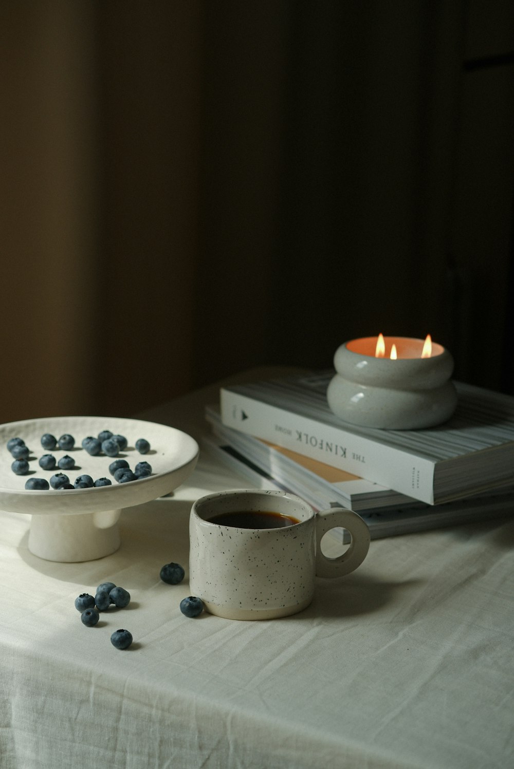 a candle and a cup of coffee on a table